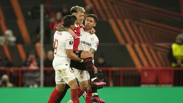 Sevilla's Marcos Acuna, left, and Sevilla's Gonzalo Montiel, right, help Manchester United's Lisandro Martinez off the pitch during the Europa League first leg quarterfinal soccer match between Manchester United and Sevilla at the Old Trafford stadium in Manchester, Thursday, April 13, 2023. (AP Photo/Dave Thompson)
