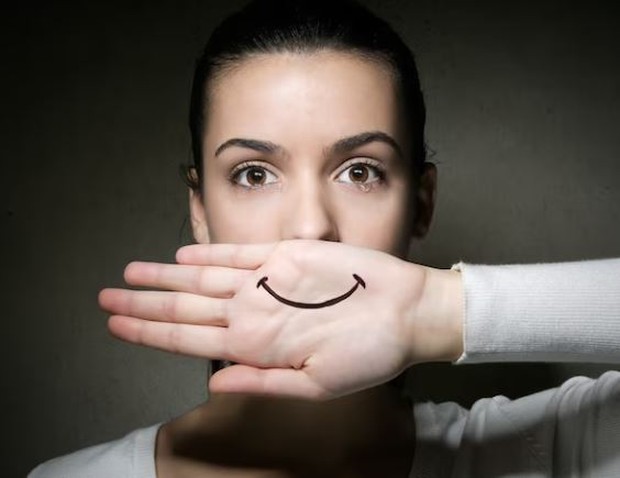 Perempuan dengan gambar mulut senyum di tangan