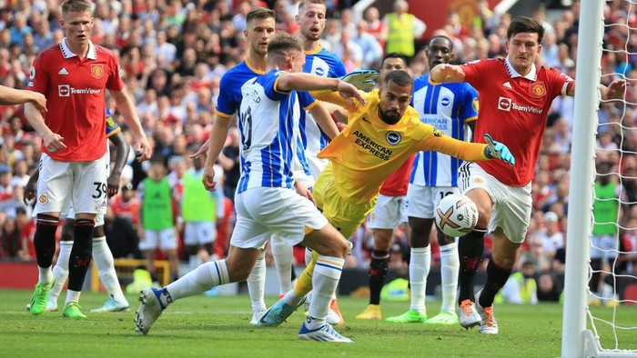Brightons Argentinian midfielder Alexis Mac Allister (C) scores an own-goal past Brightons Spanish goalkeeper Robert Sanchez during the English Premier League football match between Manchester United and Brighton and Hove Albion at Old Trafford in Manchester, north west England, on August 7, 2022. - RESTRICTED TO EDITORIAL USE. No use with unauthorized audio, video, data, fixture lists, club/league logos or live services. Online in-match use limited to 120 images. An additional 40 images may be used in extra time. No video emulation. Social media in-match use limited to 120 images. An additional 40 images may be used in extra time. No use in betting publications, games or single club/league/player publications. (Photo by Lindsey Parnaby / AFP) / RESTRICTED TO EDITORIAL USE. No use with unauthorized audio, video, data, fixture lists, club/league logos or live services. Online in-match use limited to 120 images. An additional 40 images may be used in extra time. No video emulation. Social media in-match use limited to 120 images. An additional 40 images may be used in extra time. No use in betting publications, games or single club/league/player publications. / RESTRICTED TO EDITORIAL USE. No use with unauthorized audio, video, data, fixture lists, club/league logos or live services. Online in-match use limited to 120 images. An additional 40 images may be used in extra time. No video emulation. Social media in-match use limited to 120 images. An additional 40 images may be used in extra time. No use in betting publications, games or single club/league/player publications. (Photo by LINDSEY PARNABY/AFP via Getty Images)