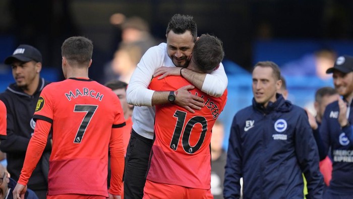Brightons head coach Roberto De Zerbi, centre left, embraces Alexis Mac Allister at the end of the English Premier League soccer match between Chelsea and Brighton and Hove Albion at Stamford Bridge stadium in London, Saturday, April 15, 2023. (AP Photo/Kirsty Wigglesworth)