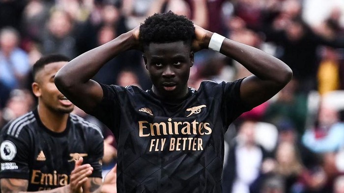 Arsenals English midfielder Bukayo Saka reacts after missing to score a penalty kick during the English Premier League football match between West Ham United and Arsenal at the London Stadium, in London on April 16, 2023. (Photo by Ben Stansall / AFP) / RESTRICTED TO EDITORIAL USE. No use with unauthorized audio, video, data, fixture lists, club/league logos or live services. Online in-match use limited to 120 images. An additional 40 images may be used in extra time. No video emulation. Social media in-match use limited to 120 images. An additional 40 images may be used in extra time. No use in betting publications, games or single club/league/player publications. /  (Photo by BEN STANSALL/AFP via Getty Images)