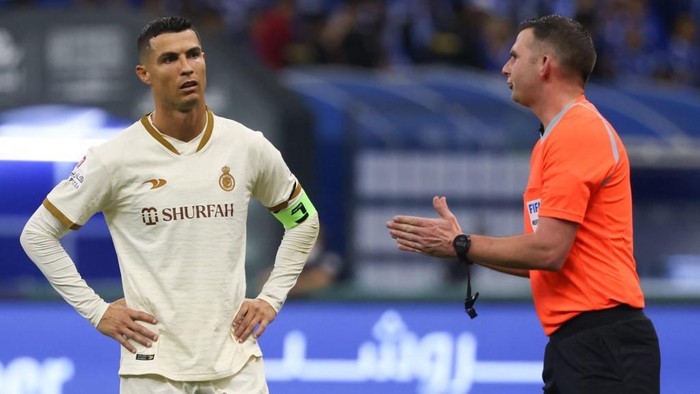 Nassrs Portuguese forward Cristiano Ronaldo (L) listens to the English referee Michael Oliver (R) during the Saudi Pro League football match between Al-Hilal and Al-Nassr at the Prince Faisal Bin Fahd stadium in the capital Riyadh on April 18, 2023. (Photo by Fayez Nureldine / AFP)