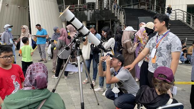 Warga antusias melihat fenomena gerhana matahari hibrida di Taman Ismail Marzuki, Jakpus, Kamis (20/4/2023).