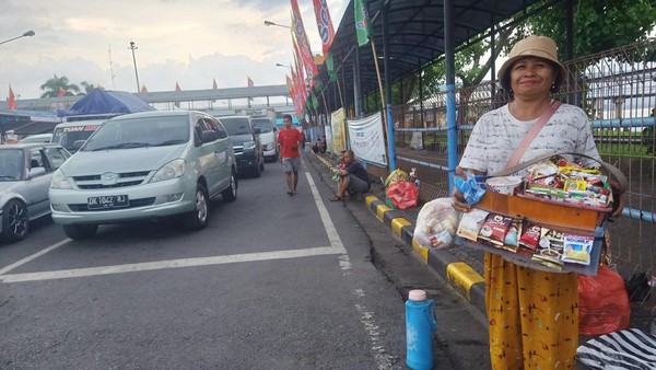 Pedagang asongan di area Terminal Kargo Gilimanuk menjajakan dagangannya kepada pemudik yang tengah antre untuk masuk ke Pelabuhan Gilimanuk, Kamis (20/4/2023). (Putu Adi Budiastrawan/detikBali)