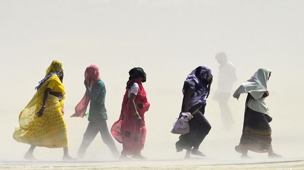 People walk through a dust storm on a hot summer day in Prayagraj on April 18, 2023. (Photo by Sanjay KANOJIA / AFP) (Photo by SANJAY KANOJIA/AFP via Getty Images)