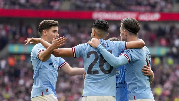 Manchester Citys Riyad Mahrez celebrates with teammates after scoring his sides third goal during the English FA Cup semi final soccer match between Manchester City and Sheffield United at Wembley stadium, in London, Saturday, April 22, 2023. (AP Photo/Alastair Grant)