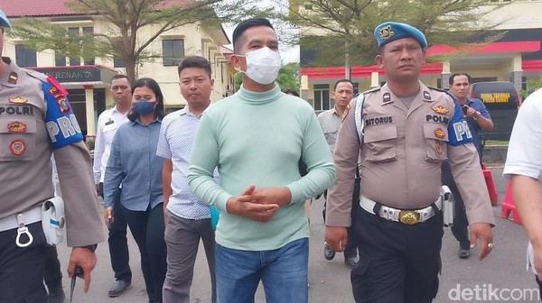 AKBP Achiruddin dikawan personel dari Propam saat akan menuju ruang pemeriksaan. (Finta Rahyuni/detikSumut)