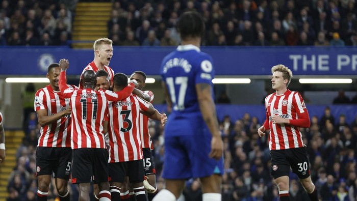 Soccer Football - Premier League - Chelsea v Brentford - Stamford Bridge, London, Britain - April 26, 2023 Brentfords Ben Mee and Mads Roerslev celebrate with teammates after their first goal scored by Chelseas Cesar Azpilicueta with an own goal Action Images via Reuters/Peter Cziborra EDITORIAL USE ONLY. No use with unauthorized audio, video, data, fixture lists, club/league logos or live services. Online in-match use limited to 75 images, no video emulation. No use in betting, games or single club /league/player publications.  Please contact your account representative for further details.