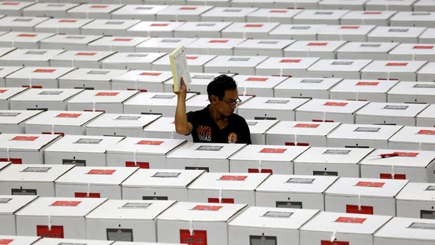 FILE PHOTO: A worker carries election materials as he prepares ballot boxes before their distribution to polling stations in a warehouse in Jakarta, Indonesia, April 15, 2019. REUTERS/Willy Kurniawan/File Photo