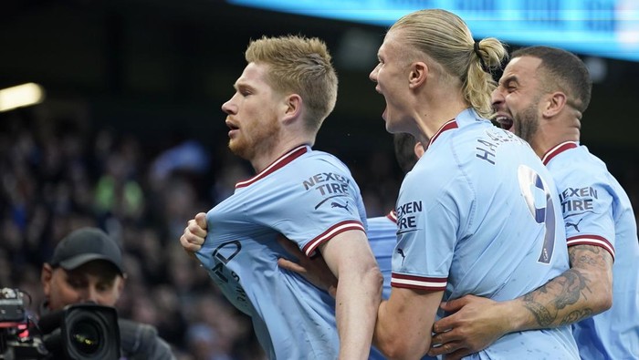Manchester Citys Kevin De Bruyne celebrates with Erling Haaland, center, and Kyle Walker, right,after scoring the opening goal during the English Premier League soccer match between Manchester City and Arsenal at Etihad stadium in Manchester, England, Wednesday, April 26, 2023. (AP Photo/Dave Thompson)