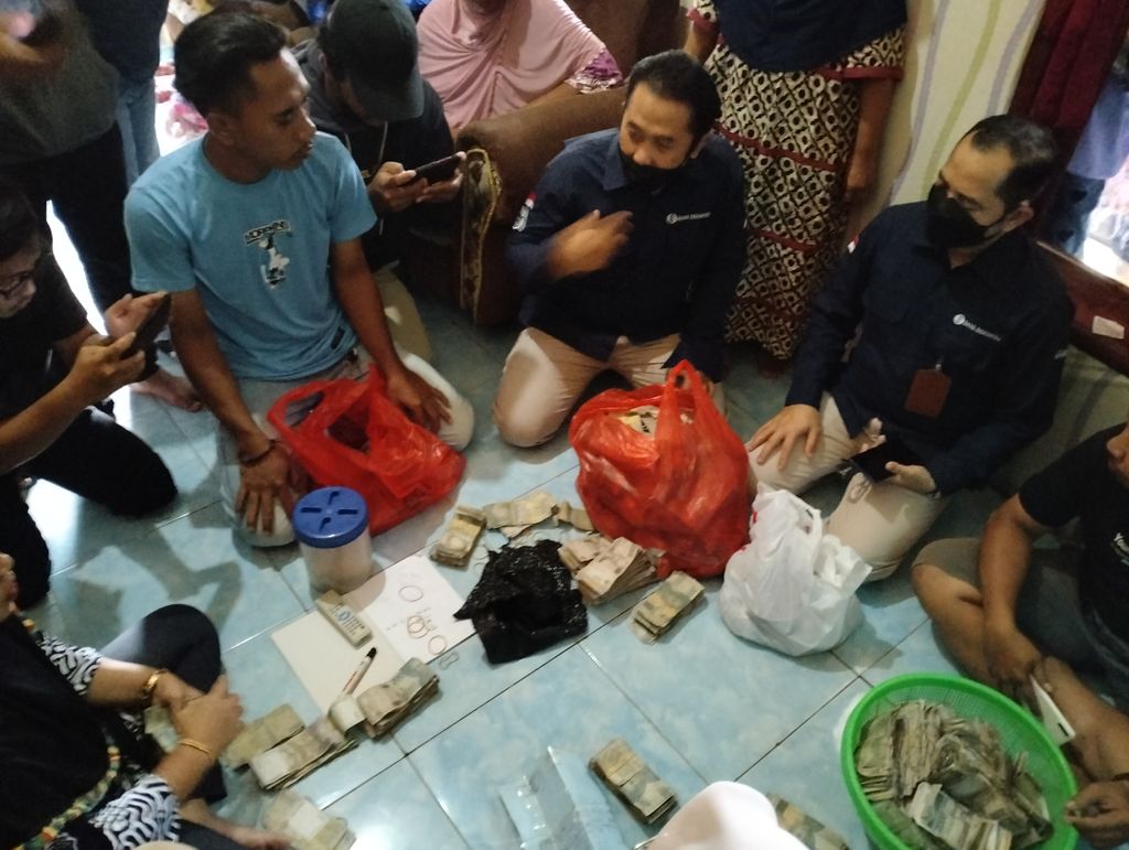 Proses penghitungan uang lusuh Kakes Sarneli oleh Tim BI dan keluarga. Totalnya Rp 77 juta