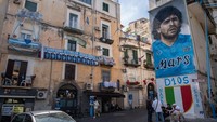 Mural Diego Maradona tak terlupakan di tengah pesta Kota Naples. Terakhir kali Napoli juara terjadi saat masih diperkuat mending legenda Argentina itu. (Foto: Silvia Bazzicalupo/Anadolu Agency via Getty Images)