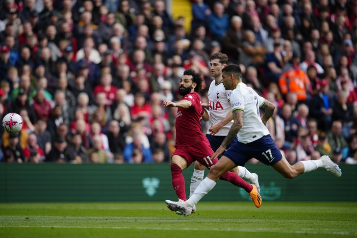 Liverpool's Mohamed Salah, left tis chased by Tottenham's Cristian Romero during an English Premier League soccer match between Liverpool and Tottenham Hotspur at Anfield stadium in Liverpool, Sunday, April 30, 2023. (AP Photo/Jon Super)