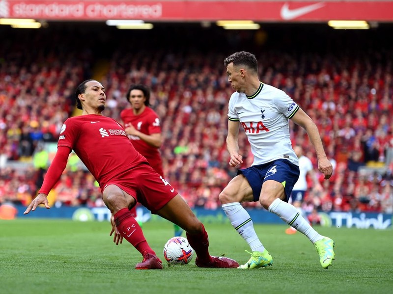 LIVERPOOL, ENGLAND - APRIL 30: Virgil van Dijk of Liverpool slips whilst under pressure from Ivan Perisic of Tottenham Hotspur   during the Premier League match between Liverpool FC and Tottenham Hotspur at Anfield on April 30, 2023 in Liverpool, England. (Photo by Michael Regan/Getty Images)