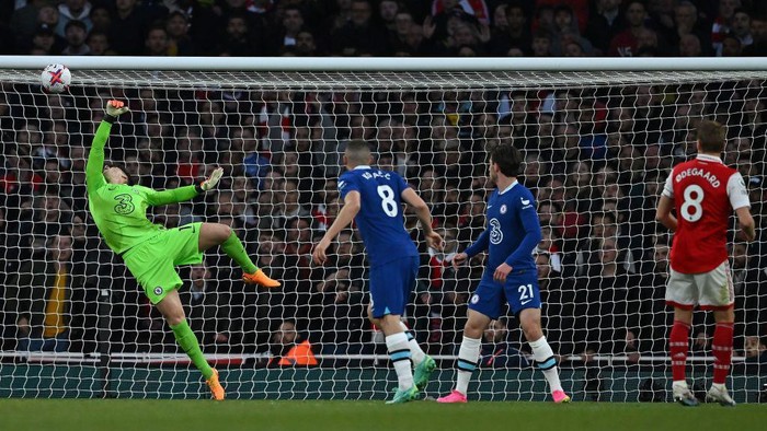 Arsenals Norwegian midfielder Martin Odegaard (R) watches the ball into the net as he scores the opening goal past Chelseas Spanish goalkeeper Kepa Arrizabalaga during the English Premier League football match between Arsenal and Chelsea at the Emirates Stadium, in London, on May 2, 2023. (Photo by Ben Stansall / AFP) / RESTRICTED TO EDITORIAL USE. No use with unauthorized audio, video, data, fixture lists, club/league logos or live services. Online in-match use limited to 120 images. An additional 40 images may be used in extra time. No video emulation. Social media in-match use limited to 120 images. An additional 40 images may be used in extra time. No use in betting publications, games or single club/league/player publications. /  (Photo by BEN STANSALL/AFP via Getty Images)