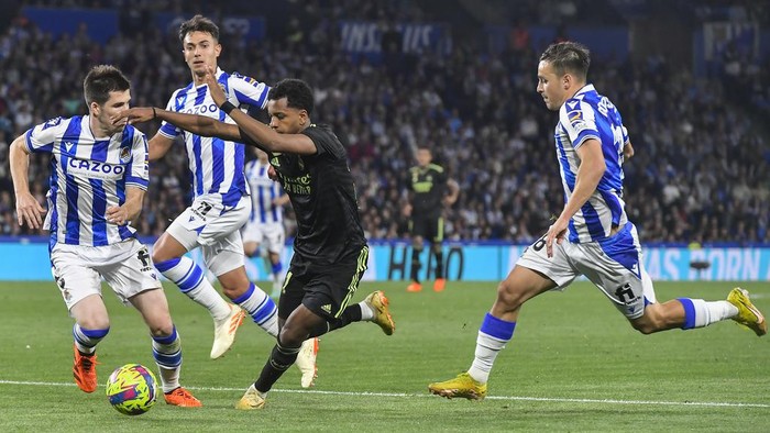 Real Madrid Tumbang di Markas Real Sociedad Real Madrid's Rodrygo, center, and Real Sociedad's Igor Zubeldia, left, fight for the ball during Spanish La Liga soccer match between Real Sociedad and Real Madrid at the Reale Arena stadium in San Sebastian, Spain, Tuesday, May 2, 2023. (AP Photo/Alvaro Barrientos)