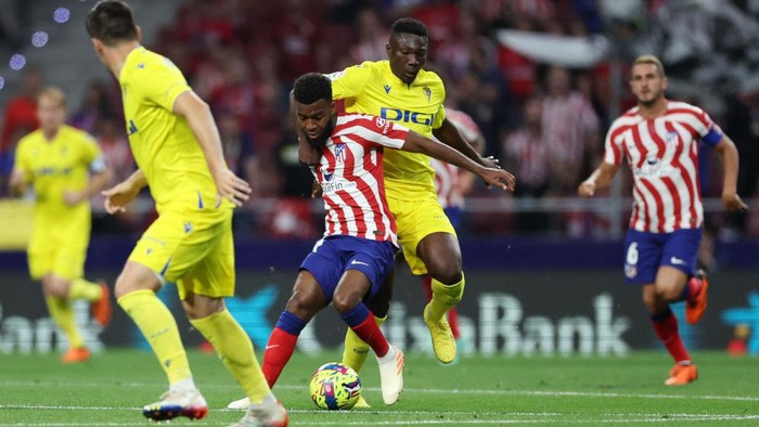 Atletico Pesta Gol, Gusur Madrid dari Posisi Dua Klasemen Atletico Madrid's French midfielder Thomas Lemar (L) vies with Cadiz's Malian midfielder Youba Diarra during the Spanish league football match between Club Atletico de Madrid and Cadiz CF at the Wanda Metropolitano stadium in Madrid on May 3, 2023. (Photo by Pierre-Philippe MARCOU / AFP) (Photo by PIERRE-PHILIPPE MARCOU/AFP via Getty Images)