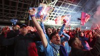 Penggemar Napoli merayakannya di Naples, Italia, setelah tim sepakbola mereka memenangkan gelar Serie A. Tim selatan menyegel trofi dengan hasil imbang 1-1 atas Udinese. AP/Alessandro Garofalo  