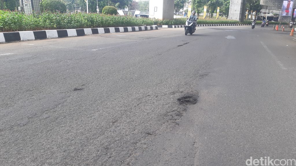 Jalan berlubang di depan kantor Kejagung RI, Jakarta, 8 Mei 2023, pagi. (Danu Damarjati/detikcom)