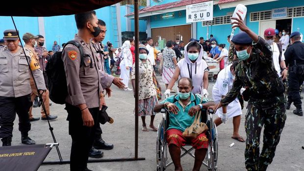 Anggota Brimob mengevakuasi pasien ke tenda sementara saat kebakaran Instalasi Rawat Darurat (IRD) RSUD Abepura di Kota Jayapura, Papua, Selasa (9/5/2023). Sumber api diduga dari lantai dua ruangan logistik RSUD Abepura dan belum diketahui penyebab kebakaran. ANTARA FOTO/Sakti Karuru/YU