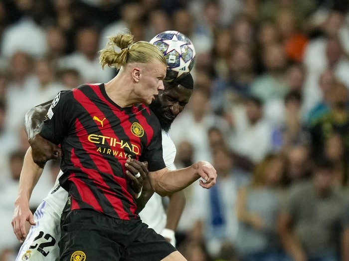 Manchester City's Erling Haaland, front, duels for the ball with Real Madrid's Antonio Rudiger during the Champions League semifinal first leg soccer match between Real Madrid and Manchester City at the Santiago Bernabeu stadium in Madrid, Spain, Tuesday, May 9, 2023. (AP Photo/Jose Breton)