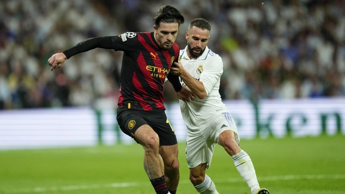 Manchester Citys Jack Grealish, left, duels for the ball with Real Madrids Dani Carvajal during the Champions League semifinal first leg soccer match between Real Madrid and Manchester City at the Santiago Bernabeu stadium in Madrid, Spain, Tuesday, May 9, 2023. (AP Photo/Jose Breton)