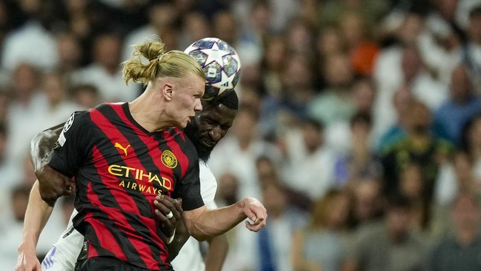 Manchester Citys Erling Haaland, front, duels for the ball with Real Madrids Antonio Rudiger during the Champions League semifinal first leg soccer match between Real Madrid and Manchester City at the Santiago Bernabeu stadium in Madrid, Spain, Tuesday, May 9, 2023. (AP Photo/Jose Breton)