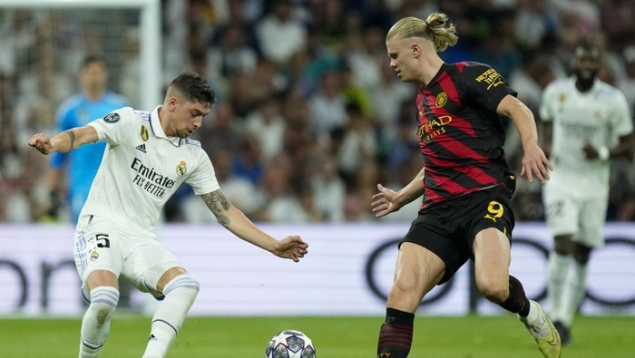 Real Madrids Federico Valverde, left, duels for the ball with Manchester Citys Erling Haaland during the Champions League semifinal first leg soccer match between Real Madrid and Manchester City at the Santiago Bernabeu stadium in Madrid, Spain, Tuesday, May 9, 2023. (AP Photo/Jose Breton)
