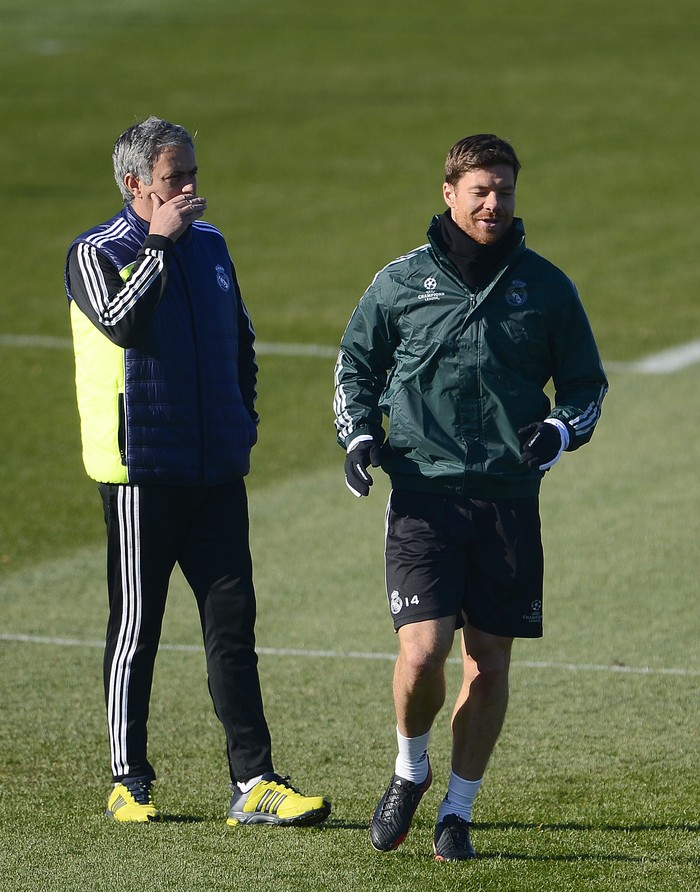 Jose Mourinho, Xabi Alonso Real Madrid's Portuguese coach Jose Mourinho (L) gestures as midfielder Xabi Alonso runs during a training session in Madrid on December 3, 2012 on the eve of the Champions League football match Real Madrid against Ajax Amsterdam. AFP PHOTO/ PIERRE-PHILIPPE MARCOU (Photo credit should read PIERRE-PHILIPPE MARCOU/AFP via Getty Images)