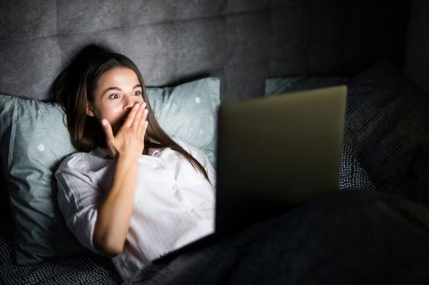 Perempuan sedang menonton film di laptop