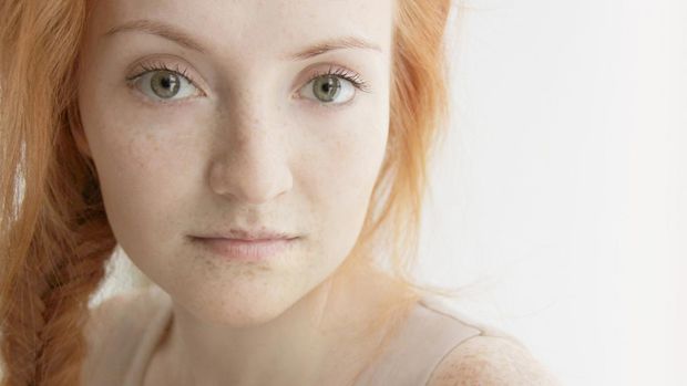 Close-up portrait of beautiful woman with fishtail braid. Looking at camera.