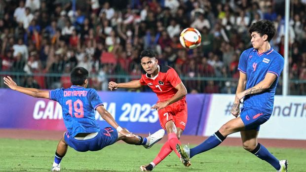 FBL-SEAGAMES-2023-CAM Indonesia's Marselino Ferdinan (C) shoots past Thailand's Chayapipat Supunpasuch (L) during the men's football final match at the 32nd Southeast Asian Games (SEA Games) in Phnom Penh on May 16, 2023. (Photo by MOHD RASFAN / AFP)