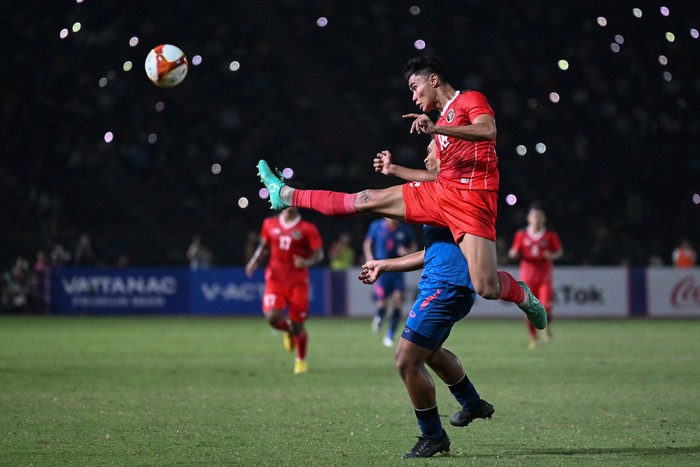 Indonesias Muhammad Ferrari (C) kicks the ball next to Thailands Yotsakon Burapha during the mens football final match at the 32nd Southeast Asian Games (SEA Games) in Phnom Penh on May 16, 2023. (Photo by MOHD RASFAN / AFP) (Photo by MOHD RASFAN/AFP via Getty Images)