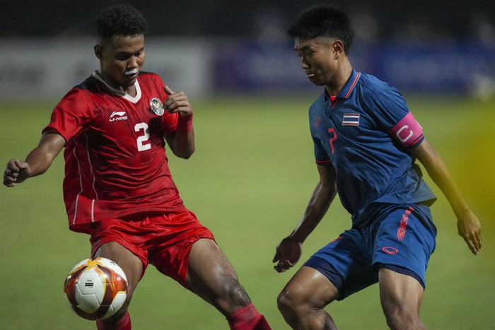 Indonesias Amiruddin Bagas, left, battles for the ball against Thailands Channarong Promsrikaew during their mens final soccer match at the 32nd Southeast Asian Games in Phnom Penh, Cambodia, Tuesday, May 16, 2023. (AP Photo/Tatan Syuflana)
