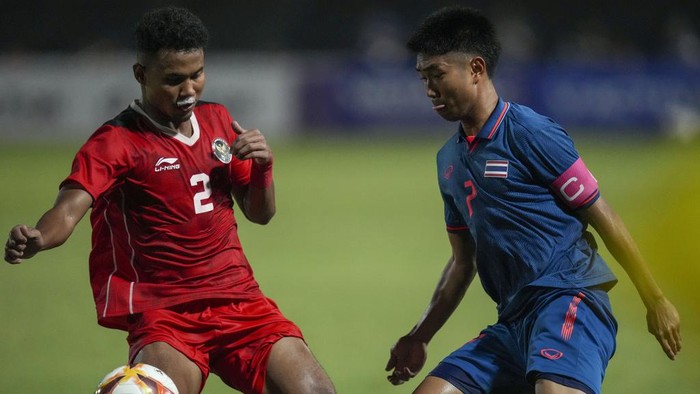 Indonesias Amiruddin Bagas, left, battles for the ball against Thailands Channarong Promsrikaew during their mens final soccer match at the 32nd Southeast Asian Games in Phnom Penh, Cambodia, Tuesday, May 16, 2023. (AP Photo/Tatan Syuflana)
