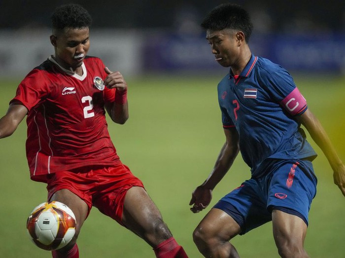 Indonesias Amiruddin Bagas, left, battles for the ball against Thailands Channarong Promsrikaew during their mens final soccer match at the 32nd Southeast Asian Games in Phnom Penh, Cambodia, Tuesday, May 16, 2023. (AP Photo/Tatan Syuflana)