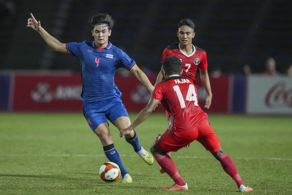 Thailand's Jonathan Khemdee, left, battles for the ball against Indonesia's Muhammad Fajar Fathur during their men's final soccer match at the 32nd Southeast Asian Games in Phnom Penh, Cambodia, Tuesday, May 16, 2023. (AP Photo/Tatan Syuflana)