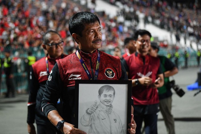 Indonesias coach Indra Sjafri holds a portrait of himself after beating Thailand in the mens football final match during the 32nd Southeast Asian Games (SEA Games) in Phnom Penh on May 16, 2023. (Photo by Nhac NGUYEN / AFP) (Photo by NHAC NGUYEN/AFP via Getty Images)