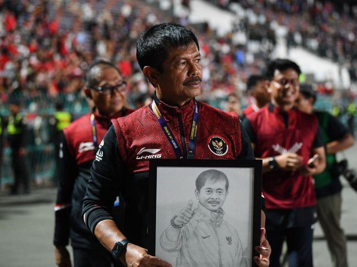 Indonesia's coach Indra Sjafri holds a portrait of himself after beating Thailand in the men's football final match during the 32nd Southeast Asian Games (SEA Games) in Phnom Penh on May 16, 2023. (Photo by Nhac NGUYEN / AFP) (Photo by NHAC NGUYEN/AFP via Getty Images)