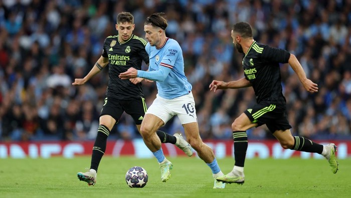 MANCHESTER, ENGLAND - MAY 17: Jack Grealish of Manchester City runs with the ball from Federico Valverde of Real Madrid during the UEFA Champions League semi-final second leg match between Manchester City FC and Real Madrid at Etihad Stadium on May 17, 2023 in Manchester, England. (Photo by Clive Brunskill/Getty Images)