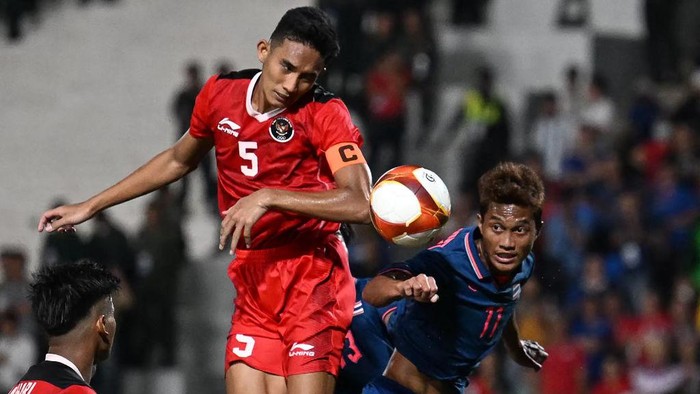 Indonesias Rizky Ridho Ramadhani (C) and Thailands Anan Yodsangwal (R) vie for the ball during the mens football final match at the 32nd Southeast Asian Games (SEA Games) in Phnom Penh on May 16, 2023. (Photo by MOHD RASFAN / AFP) (Photo by MOHD RASFAN/AFP via Getty Images)