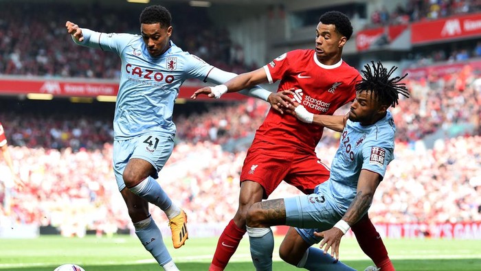 Liverpools Dutch striker Cody Gakpo (C) vies with Aston Villas English midfielder Jacob Ramsey (L) and Aston Villas English defender Tyrone Mings (R) during the English Premier League football match between Liverpool and Aston Villa at Anfield in Liverpool, north west England on May 20, 2023. (Photo by PETER POWELL / AFP) / RESTRICTED TO EDITORIAL USE. No use with unauthorized audio, video, data, fixture lists, club/league logos or live services. Online in-match use limited to 120 images. An additional 40 images may be used in extra time. No video emulation. Social media in-match use limited to 120 images. An additional 40 images may be used in extra time. No use in betting publications, games or single club/league/player publications. /  (Photo by PETER POWELL/AFP via Getty Images)
