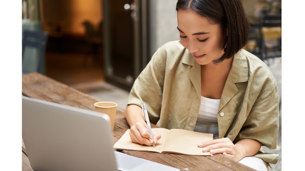 Ilustrasi seorang perempuan yang terlihat tengah menulis.