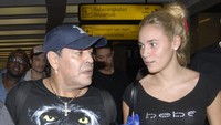 Maradona datang bersama pacaranya saat itu, Rocio Olivia. Begini momen keduanya berada di Bandara Soekarno-Hatta, pada tanggal 26 Juni 2013. (Foto: BIMA SAKTI/AFP via Getty Images)