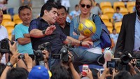 Maradona menendang bola untuk diperebutkan banyak penonton. (Foto: BAY ISMOYO/AFP via Getty Images)