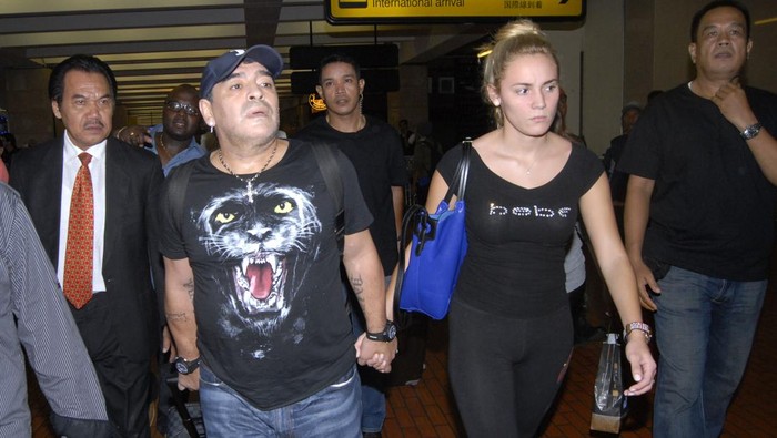 diego maradona ke jakarta,diego maradona ke indonesia,diego maradona,rocio olivia Argentina's football legend Diego Maradona (centre L) and his girlfriend Rocio Olivia (R) arrive at the airport in Jakarta on June 29, 2013. Maradona will attend several football events during his one-day visit. AFP PHOTO / Bima SAKTI (Photo by BIMA SAKTI / AFP) (Photo credit should read BIMA SAKTI/AFP via Getty Images)