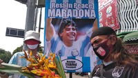 Diego Maradona cukup dicintai di Indonesia. Pada 2020, saat legenda Argentina itu meninggal dunia, banyak masyarakat Tanah Air berduka. Di Solo, sebuah tribute bahkan digelar untuk melepas sosok yang punya gol Tangan Tuhan itu. (Foto: ANWAR MUSTAFA/AFP via Getty Images)