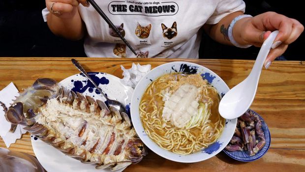 Digell Huang, 34, one of the two reserved customers tries the giant isopod ramen in Taipei, Taiwan May 27, 2023. REUTERS/Ann Wang