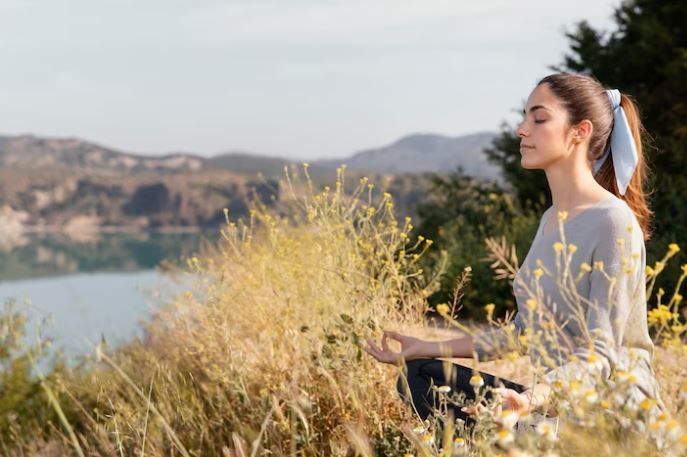 Perempuan sedang duduk di alam terbuka
