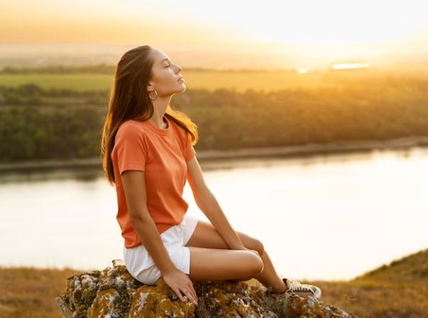 Perempuan sedang duduk di alam terbuka